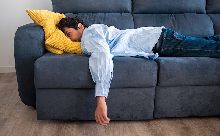 Man on couch frustrated from interaction with difficult project stakeholder