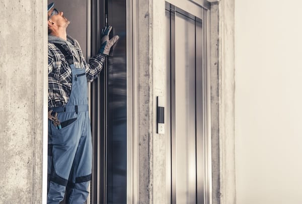 Technician checking elevator. Make sure to check if elevators and other facilities are operative on the day you plan to move offices